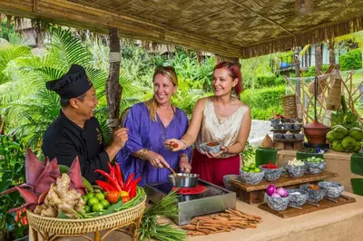 a group of people standing around a table with food at Keemala - Tent Pool Villa in Kamala Beach