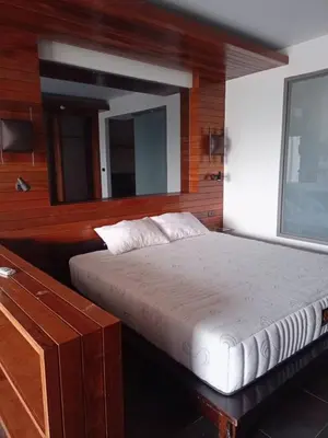 a bedroom with a white bed with a mirror at The green golf resident in Kathu