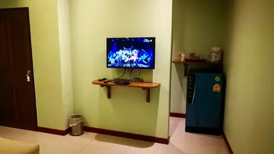 a corner of a room with a television and a refrigerator at Pennapa Chalet in Chalong