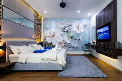 a bedroom with a large white flower mural on the wall at Karon Beach Residence in Karon Beach