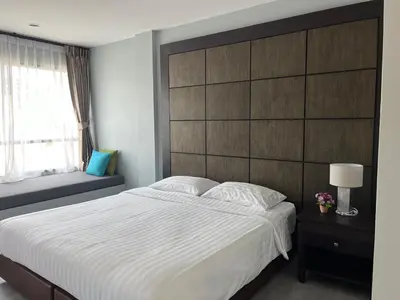 a bedroom with a large bed and a large headboard at Afiyath Residence in Kamala Beach