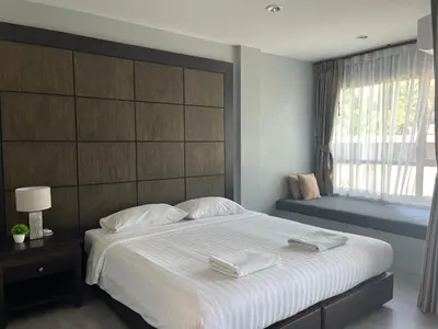 a bedroom with a large bed with two towels on it at Afiyath Residence in Kamala Beach