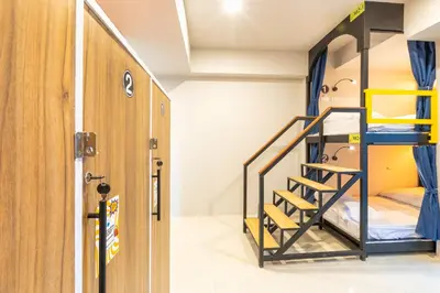 a room with two bunk beds and a door at Mellow Poshtel - Kata Beach in Kata Beach