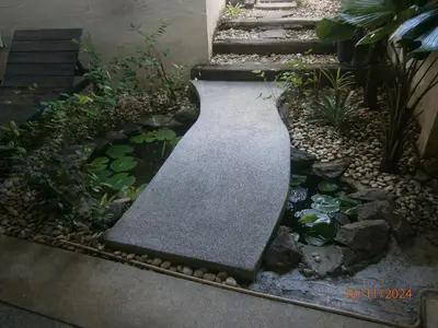 a garden with a walkway and a pond at Infinity Boutique Hotel Kata Beach in Kata Beach