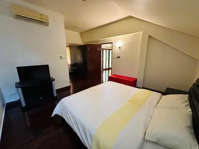 a bedroom with a white bed and a television at Patong Beach\u68ee\u6797\u5c4b111 in Patong Beach