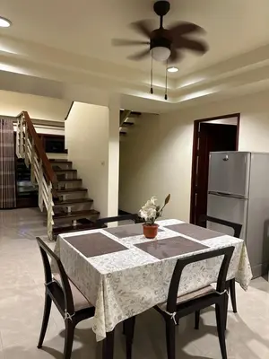 a dining room with a table and a refrigerator at Patong Beach\u68ee\u6797\u5c4b111 in Patong Beach