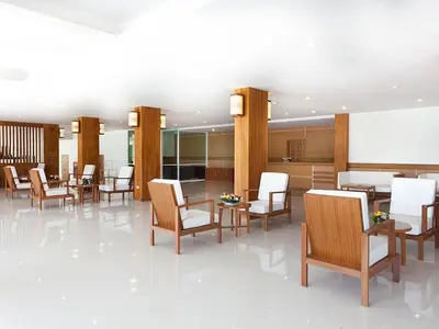a restaurant with tables and chairs and a white floor at Rawai Princess Hotel in Rawai Beach