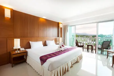 a bedroom with a large bed and a balcony at Rawai Princess Hotel in Rawai Beach