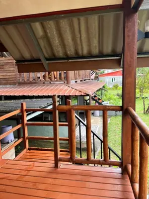 an open porch with a wooden deck with a roof at ThaKhaopierBangalow in Ban Bang Chak