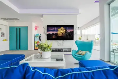 a living room with blue chairs and a tv at \u84dd\u8272\u82ad\u4e1c\u8c6a\u534e5\u5367\u6d77\u666f\u522b\u5885 in Patong Beach