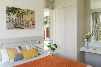 a bedroom with a bed with colorful pillows at Friendly Kamala Garden View in Kamala Beach