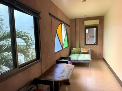 a living room with a bench and a stained glass window at Kamala beach house 100m to the beach in Kamala Beach