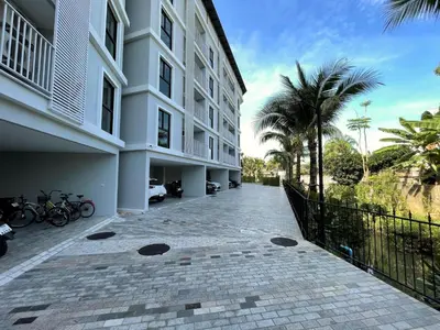 a building with a sidewalk next to a building with palm trees at Private apartment Title V Condo by Lofty in Rawai Beach