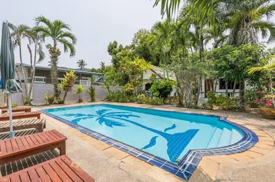 a swimming pool in a yard with two benches at Baan Coconut in Bang Tao Beach