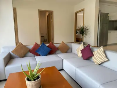 a living room with a couch with colorful pillows at Trichada Tropical pool villa by Lofty in Bang Tao Beach