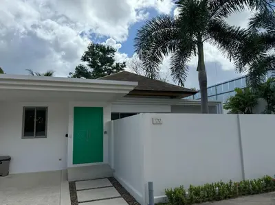a white house with a green door and a fence at Trichada Tropical pool villa by Lofty in Bang Tao Beach