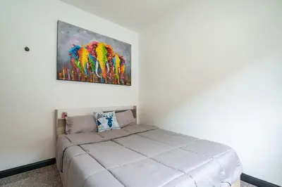 a bedroom with a bed and a painting on the wall at Pool Villa 3 Bedrooms, Closeby Patong, Chic and Quiet in Kathu