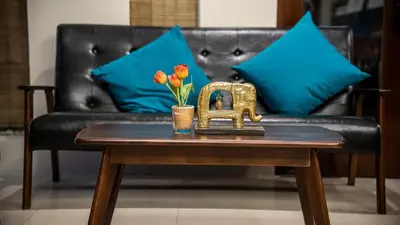 a table with a gold elephant and flowers on a couch at Hemingway's Hotel in Patong Beach