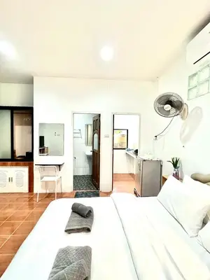 a white bedroom with a large white bed and a kitchen at Yada House Alina Cottage in Nai Yang Beach