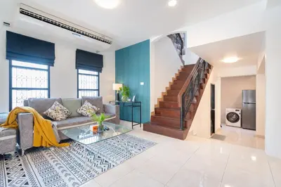 a living room with a couch and a staircase at Cozystay Center of Patong near Bangla Road in Patong Beach