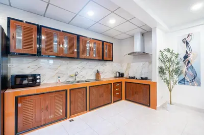a kitchen with wooden cabinets and a sink at Cozystay Center of Patong near Bangla Road in Patong Beach