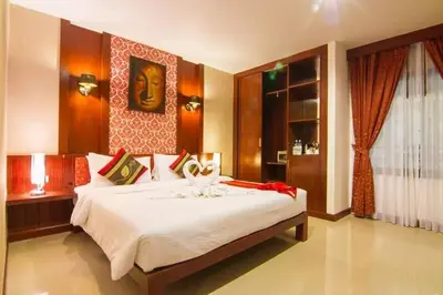 a bedroom with a large white bed in a room at Patong Hemingways Hotel in Patong Beach