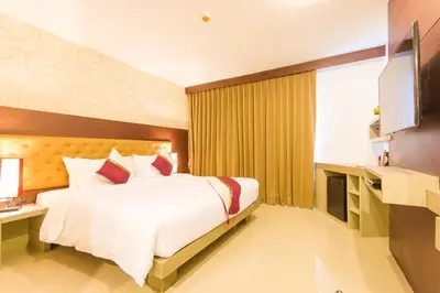 a hotel room with a bed and a television at Hemingways Silk Hotel in Patong Beach