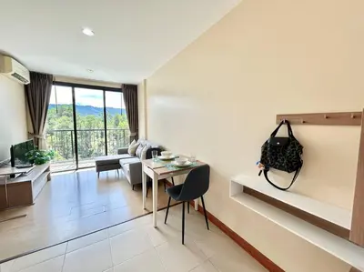 a living room with a couch and a table in a room at 1 Large Bedroom in Prime Bangtao in Bang Tao Beach