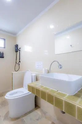 a bathroom with a sink and a toilet and a tub at Sunrise Serenity Phuket Resort in Karon Beach