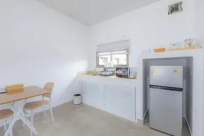 a kitchen with a white refrigerator and a table at Sunrise Serenity Phuket Resort in Karon Beach