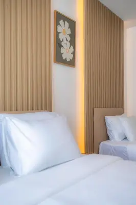 a bedroom with two beds and a picture on the wall at Sunrise Serenity Phuket Resort in Karon Beach