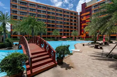 a bridge over a pool next to a large building at 1 BR apartment 777 Beach Condotel in Mai Khao Beach