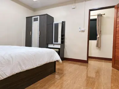 a bedroom with a bed and a dresser and a mirror at บ้านสวยกานต์ชนิต in Ko Yao Noi