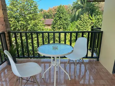 a table and two chairs on a balcony at บ้านสวยกานต์ชนิต in Ko Yao Noi