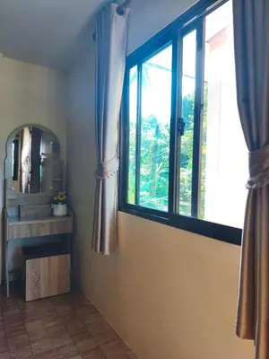 a living room with a window and a mirror at บ้านสวยกานต์ชนิต in Ko Yao Noi
