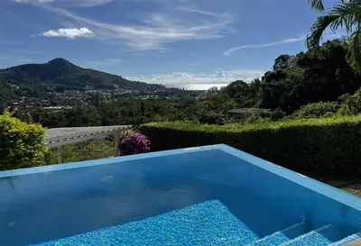 a blue swimming pool with a view of the mountains at Kamala Heights Villa in Kamala Beach