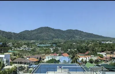 a view of a city with a swimming pool and mountains at Charming Beachside Studio in Rawai Beach