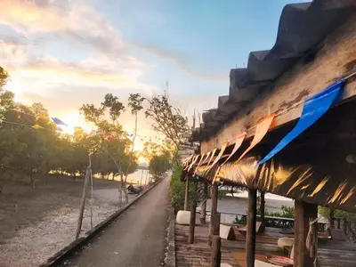 a building on the beach with the sun setting at Ganchanid House in Ko Yao Noi