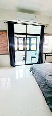 a bedroom with a bed and a large window at The pink palace in Karon Beach