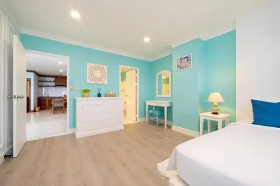 a bedroom with a white bed and blue walls at Waterfront High Tide Suite - Ocean View in Karon Beach