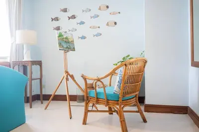 a chair in a room with a wall with fish decals at Waterfront High Tide Suite - Ocean View in Karon Beach