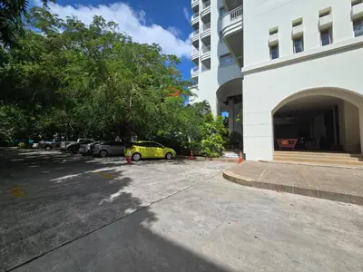 a car parked in a parking lot next to a building at Waterfront High Tide Suite - Ocean View in Karon Beach