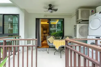 a balcony with a table and chairs and a kitchen at Neatest Apartment 50m To Main Street And Beach C149 in Rawai Beach