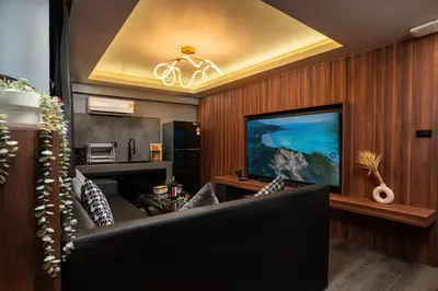 a living room with a couch and a television at Three Double U - Kalim Sea View in Patong Beach