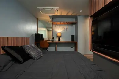 a bedroom with a large bed with a flat screen tv at Three Double U - Kalim Sea View in Patong Beach
