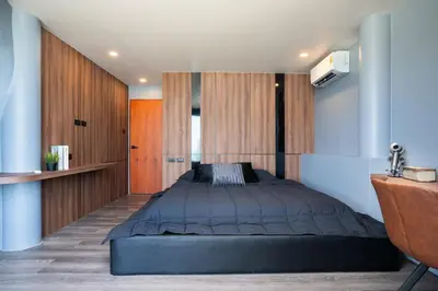 a bedroom with a bed and wooden cabinets at Three Double U - Kalim Sea View in Patong Beach