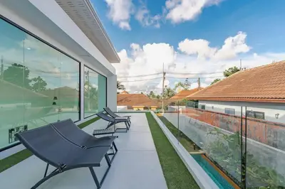 a patio with two chairs and a swimming pool at Peaceful Paradise in Saiyuan Villa V147 in Rawai Beach