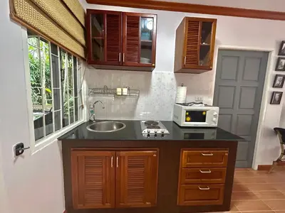 a kitchen with a sink and a microwave at Cozy Garden Cottage in Ao Nang