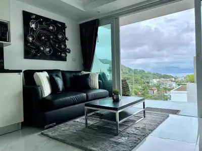 a living room with a black couch and a table at Kata Ocean View 1 bedroom 50 m2 in Kata Beach
