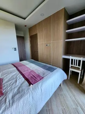 a bedroom with a large bed and a chair at One bedroom apartment Calypso Garden in Phuket Town